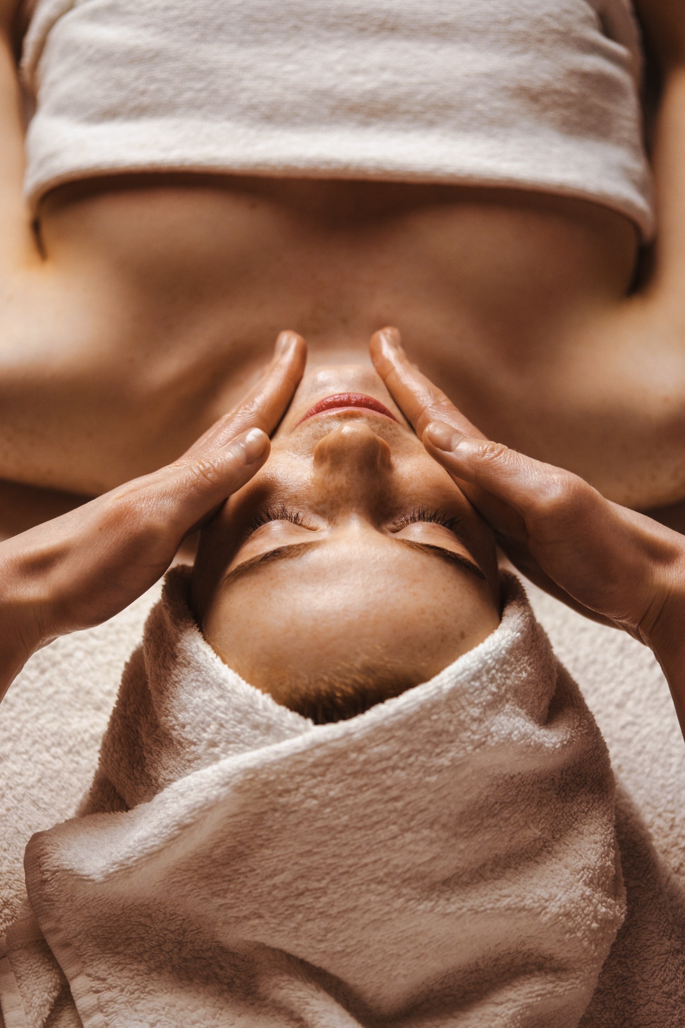 Hands providing a facial skincare treatment